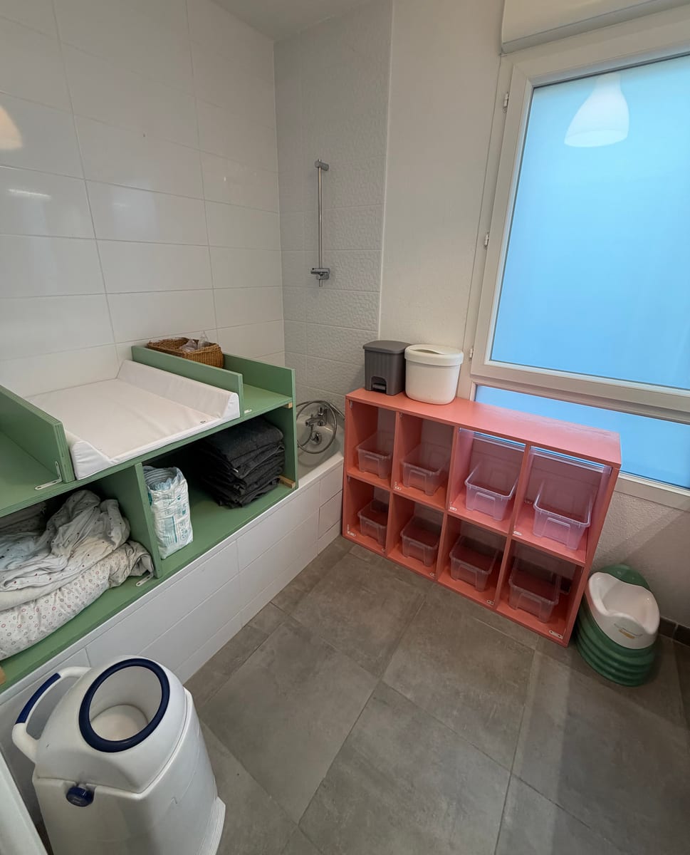 Espace de change avec plan à langer, rangements et matériel de soin.